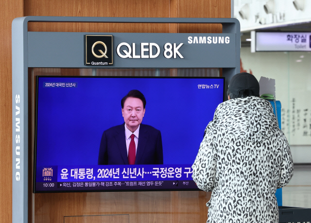새해 첫날인 1일 오전 서울역 대합실에서 한 시민이 윤석열 대통령의 2024년 신년사 방송을 지켜보고 있다. 연합뉴스